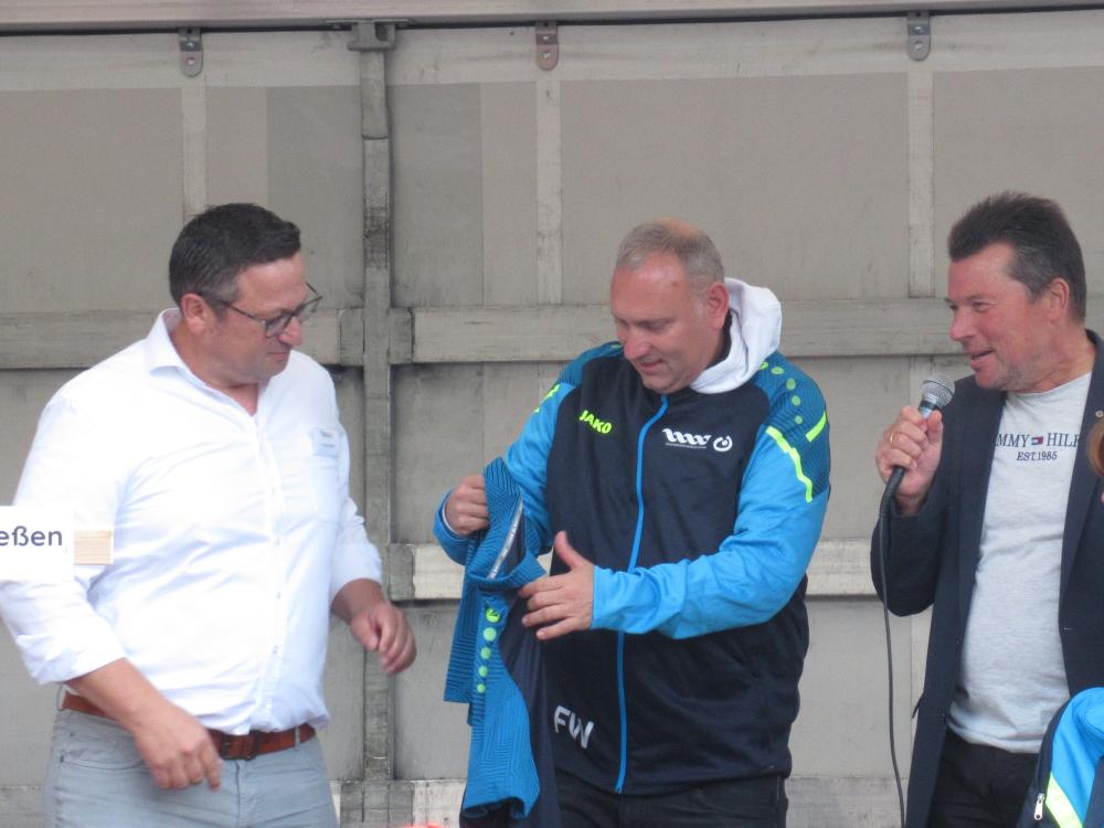 Franz Müller, Leiter Hochfränkische Werkstätten, ein Sportler der Hochfränkischen Werkstätten und PP Dr. Harald Fichter bei der Übergabe